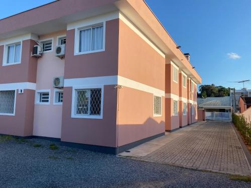 a pink and orange building with a sidewalk at RCM Vilas - STUDIO n 06 in Joinville