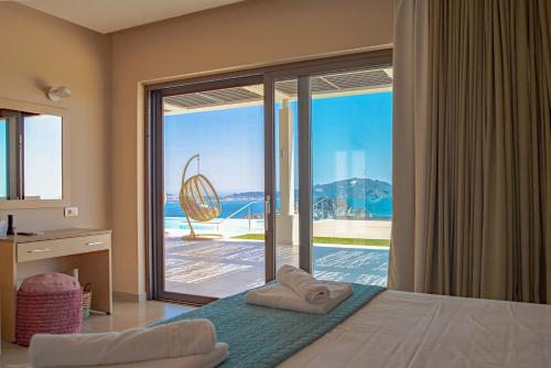 a bedroom with a bed with a view of the ocean at Lamar Private Luxury Villas in Marathias