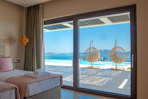 a bedroom with a bed and a view of the ocean at Lamar Private Luxury Villas in Marathias