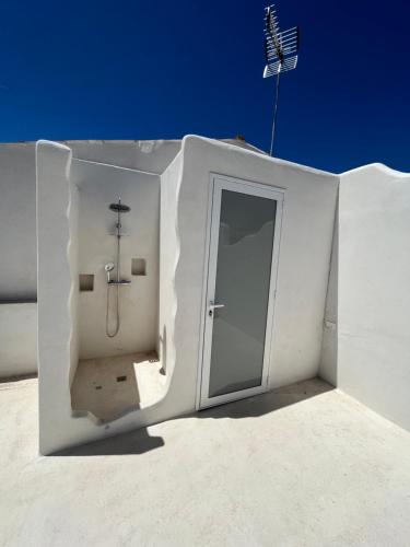 マリーナ・ディ・ラグーザにあるVilla Afrodite mediterranea 2022のシャワーとドアのある白い建物