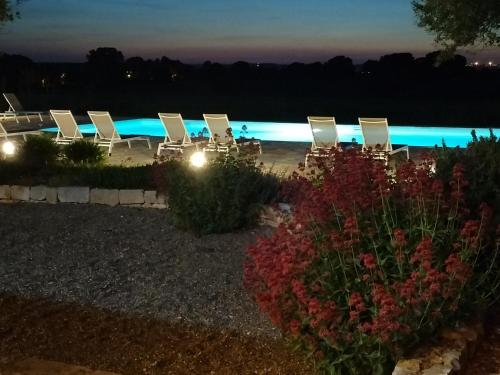 a row of chairs on the beach at night at Agriturismo La Civetta in Gioia del Colle