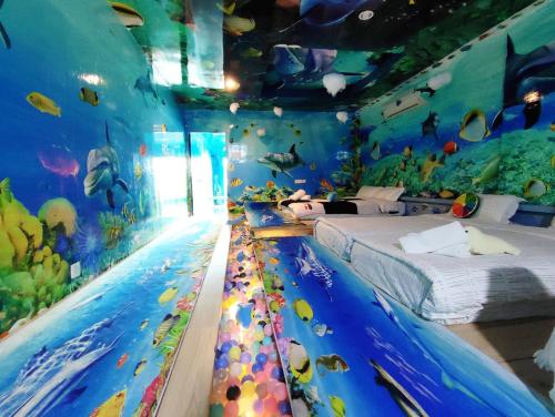 a room with two beds and an aquarium at Marina Island Ocean Theme @ Lumut Sitiawan in Lumut
