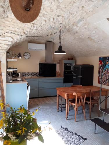 eine Küche und ein Esszimmer mit einem Holztisch in der Unterkunft les grés logis de charme jean loup in Grignan