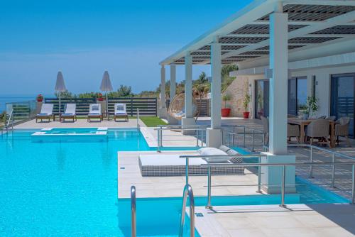 a swimming pool with a view of the ocean at Lamar Private Luxury Villas in Marathias