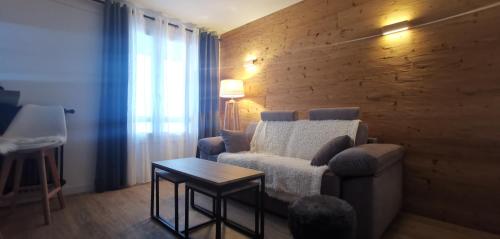 sala de estar con sofá y mesa en Chaleureux Studio au centre de Valberg, en Valberg