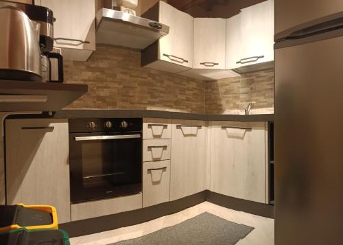 a kitchen with white cabinets and a stove top oven at La casa di Samarcanda in Uliveto Terme