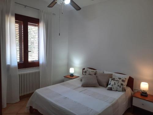 a bedroom with a white bed and a window at Villa con piscina TERRAZZA DAL PICCIOTTO in Marsala