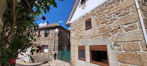 a stone building with a green gate in front of it at Casa do Quinteiro in Arcos de Valdevez