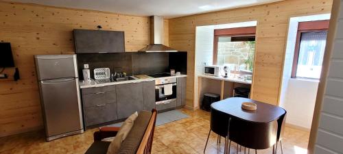 a kitchen with a refrigerator and a table in a room at Casa do Quinteiro in Arcos de Valdevez
