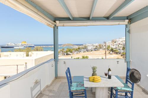a balcony with a table and chairs and a view of the ocean at Katy's Home in Naxos Chora