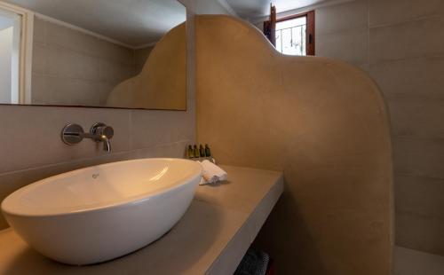 a bathroom with a white sink and a mirror at Anamnesis City Spa in Fira