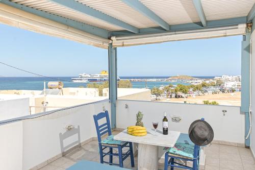 einen Tisch und Stühle auf einem Balkon mit Meerblick in der Unterkunft Katy's Home in Naxos Chora