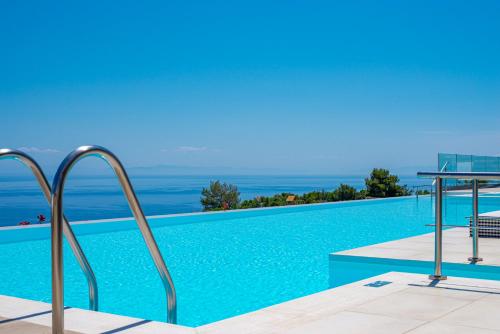 a swimming pool with a view of the ocean at Lamar Private Luxury Villas in Marathias
