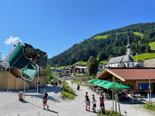 a group of people walking around a town with a mountain at Sonnenalp Sonnhang de Luxe in Niederau