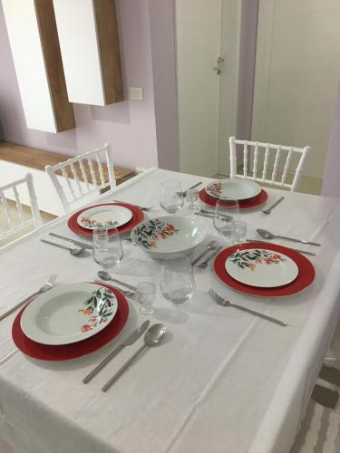 ヴロラにあるLovely apartament with the sea viewの赤白の皿とワイングラスを用意したテーブル