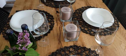 a wooden table with wine glasses and flowers on it at Apartamenty Pod Uwalonym Dębem in Jeżów Sudecki