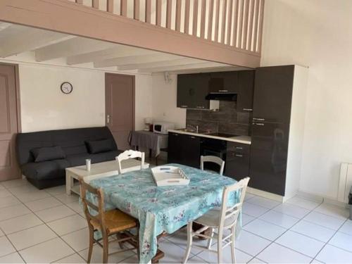 a kitchen and living room with a table and chairs at Gîte le verger in Soulignonne