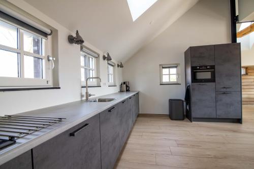 a kitchen with a sink and a refrigerator at erve Middendorp in Ansen