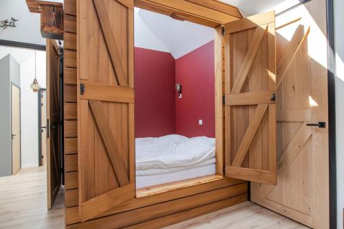 a small room with a bed inside of a wooden door at erve Middendorp in Ansen