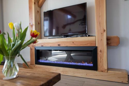 a fireplace in a wooden entertainment center with a tv at erve Middendorp in Ansen