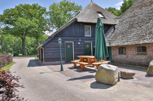 a building with a picnic table and a umbrella at erve Middendorp in Ansen