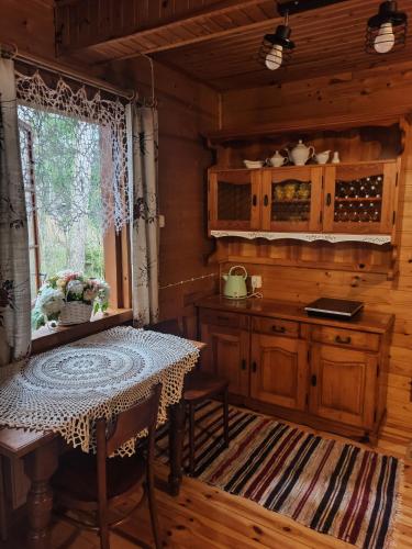 a kitchen with a table and a window in a cabin at Agroturystyka Bora Zdrój in Narewka