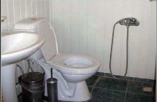 uma casa de banho com um WC branco e um lavatório. em Bayrams Tree Houses em Olympos