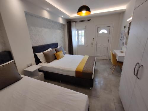 a bedroom with two beds and a desk and a sink at Studios Apollon in Chrysi Ammoudia