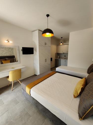 a bedroom with a large bed and a desk at Studios Apollon in Chrysi Ammoudia
