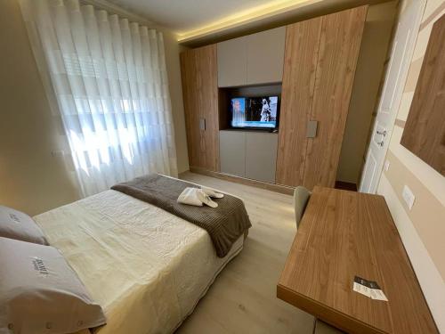 a bedroom with a bed and a table and a tv at Dimora Lucia in Troia