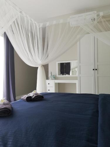 a bedroom with a blue bed with a canopy at Pool Villa Nita in Ban Na Klang