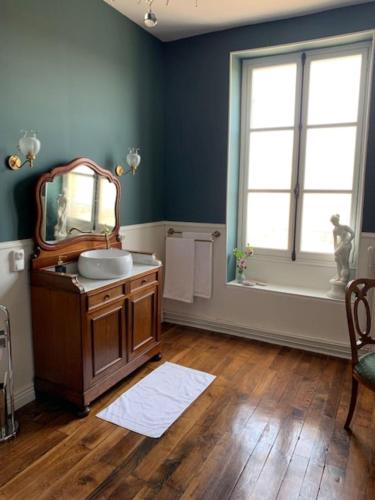 baño con espejo, lavabo y ventana en Maison de l'Aumance, en Meaulne