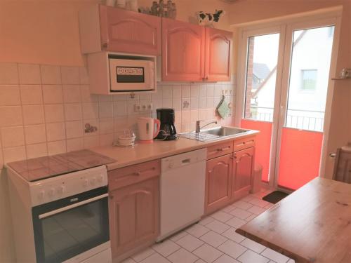 una cucina con mobili in legno e un lavello di Biene's Bärenstube a Elze