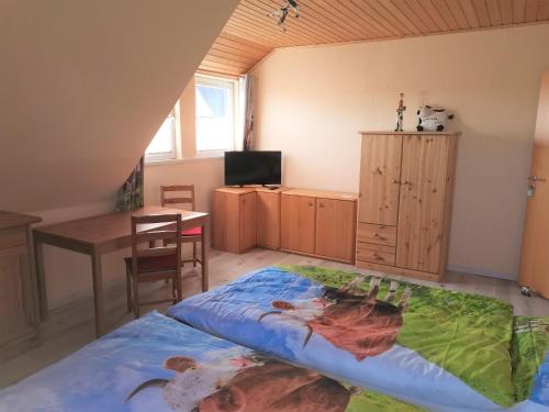 a bedroom with a bed and a table and a desk at Biene's Bärenstube in Elze