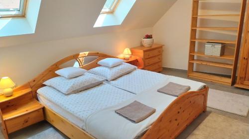um quarto com uma cama de madeira e 2 almofadas em Zichy Ház em Keszthely