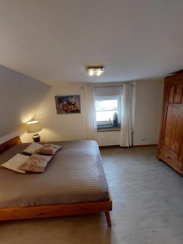 a bedroom with a large bed and a window at Landhof Osterdeich in Emmelsbüll-Horsbüll