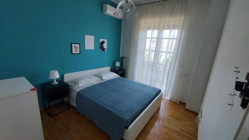 una camera blu con un letto e una finestra di Le Strelizie ad Arnesano