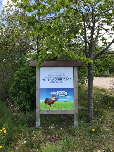 un cartello sull'erba vicino a un albero di Urlaubswind a Niebüll