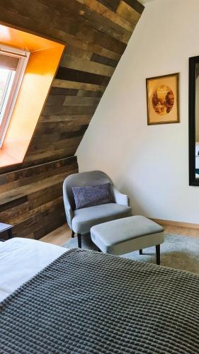 a bedroom with a bed and a chair and a window at B&B Plitvice Holiday Lodge in Plitvička Jezera