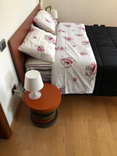 a bedroom with a bed and a table with a lamp at Appartamento A casa di Tamy in Fabriano