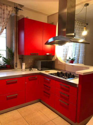 a kitchen with red cabinets and a stove at Appartamento A casa di Tamy in Fabriano