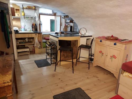 eine Küche mit einer Theke und Stühlen in einem Zimmer in der Unterkunft Studio atypique rue de Turin (ancienne étable de village) in Breil-sur-Roya