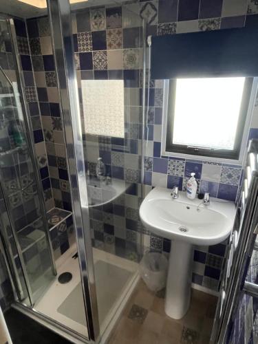 a bathroom with a sink and a shower at Private Holiday home in calm site in Wootton Bridge