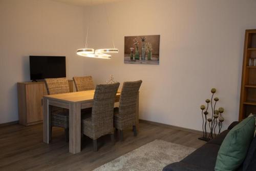 法倫達爾的住宿－Ferienwohnung Viventum34，一间带木桌和椅子的用餐室