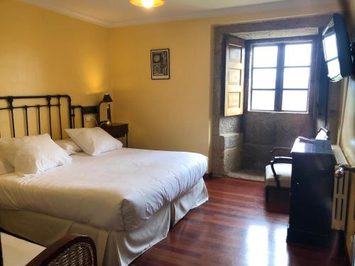 a bedroom with a large bed and a window at Casa Grande de Fuentemayor in Silleda