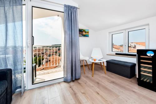 ein Wohnzimmer mit einer großen Glastür, die auf einen Balkon führt in der Unterkunft Casa Bellavista Sea View in Rovinj