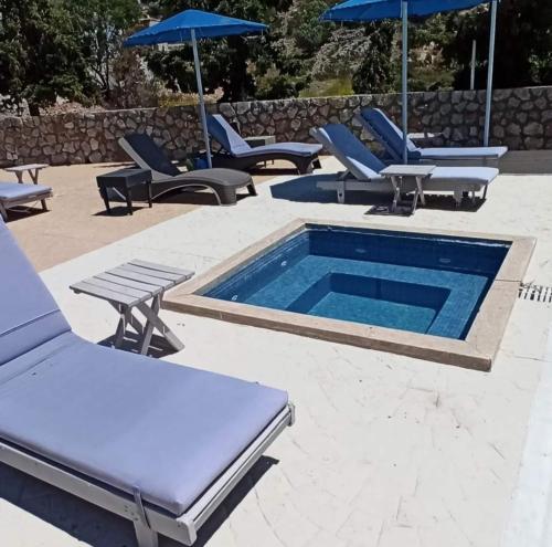 um grupo de espreguiçadeiras e uma piscina em Villa Maria em Kalymnos