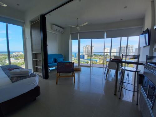 a room with a bed and a kitchen with a table at Terrazas Tayrona Travelers Apartamentos y Suites in Santa Marta