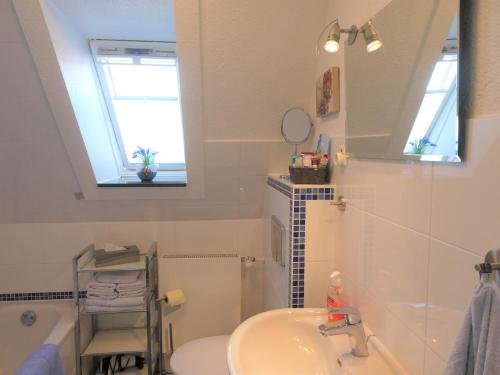 a bathroom with a sink and a tub and a mirror at Sommerwind in Eutin