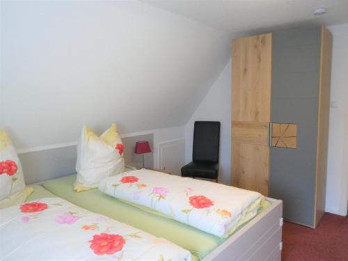 a bedroom with two beds and a chair at Sommerwind in Eutin